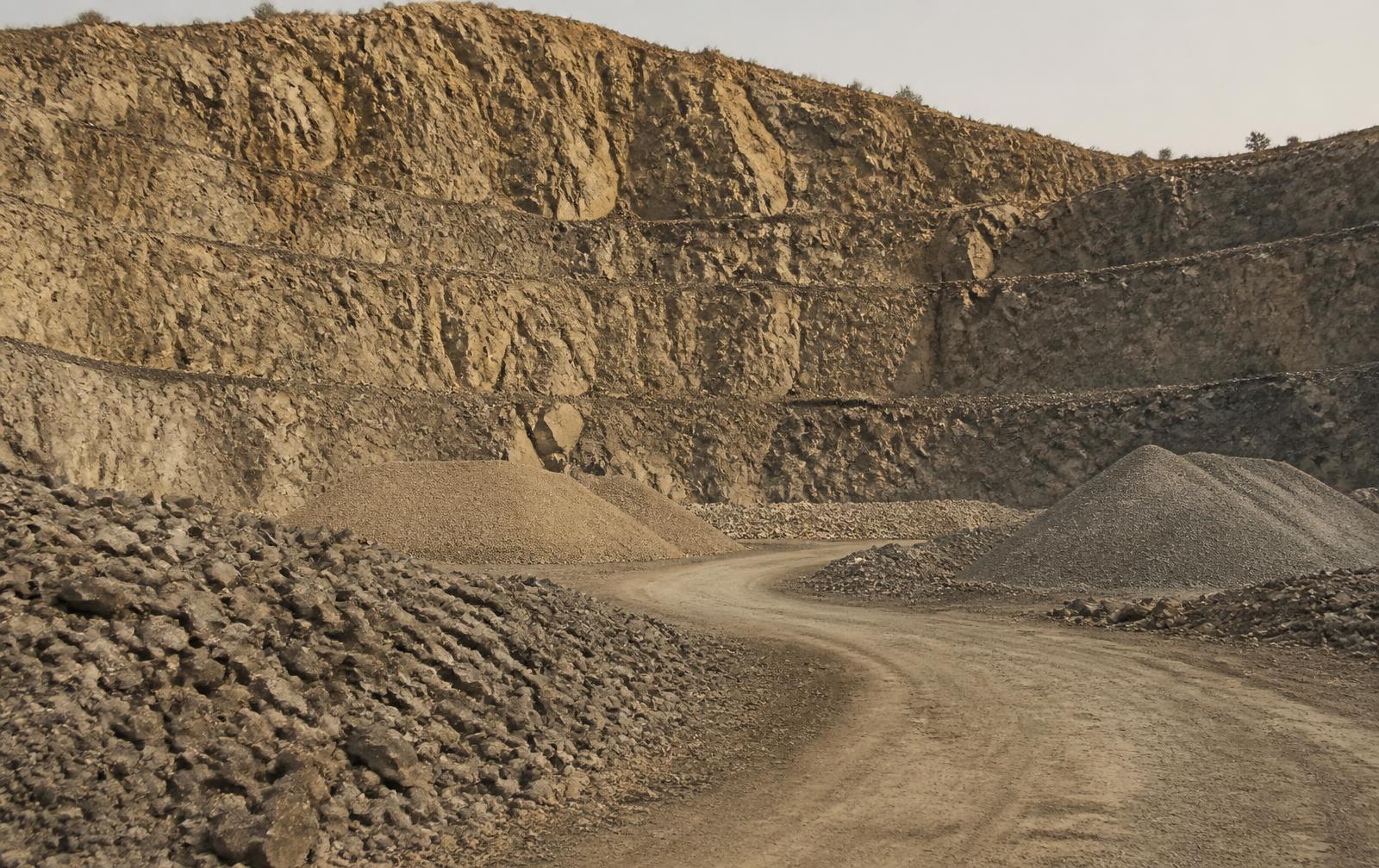 Quarry face and aggregate stockpiles under open sky