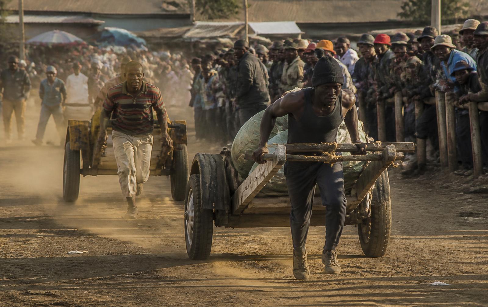 Mkokoteni operators racing loaded handcarts at a grassroots event